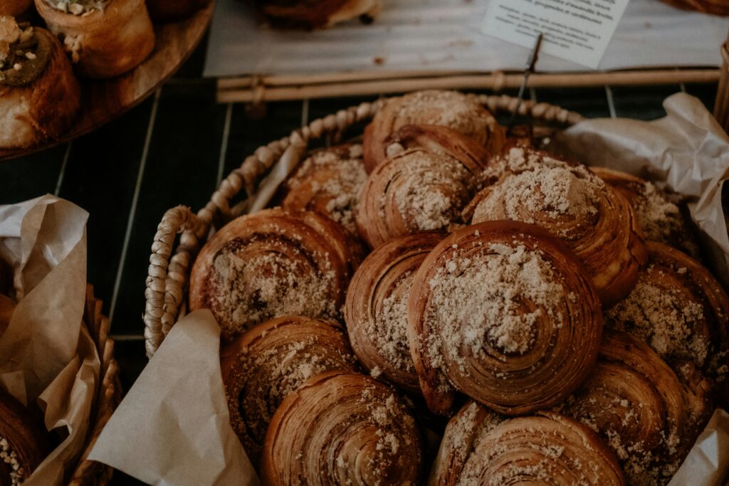 "Freshly baked, flaky croissant dusted with a warm, aromatic cinnamon powder, available at the best cake shops in Thrissur."
